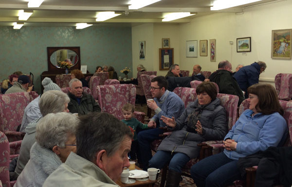 Picture of people enjoying cake, a cuppa and a chat