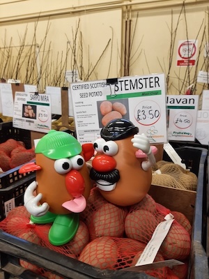 Picture of a box of potatoes, two with a funny face 